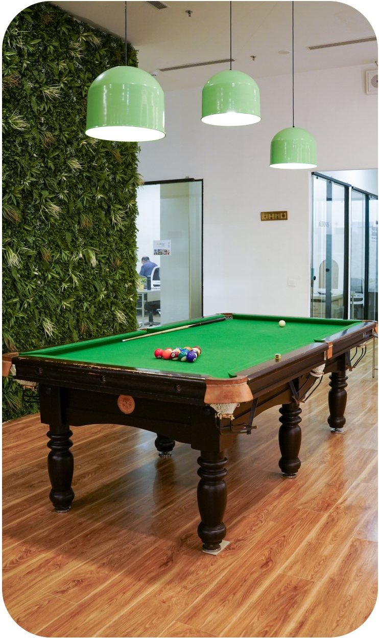 Pool table beside a green wall