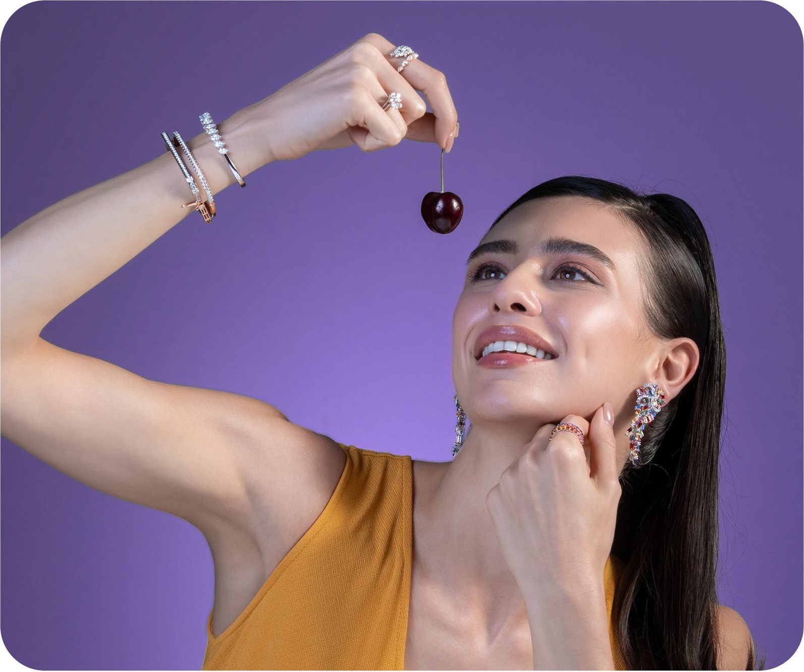 Model in yellow holding a cherry